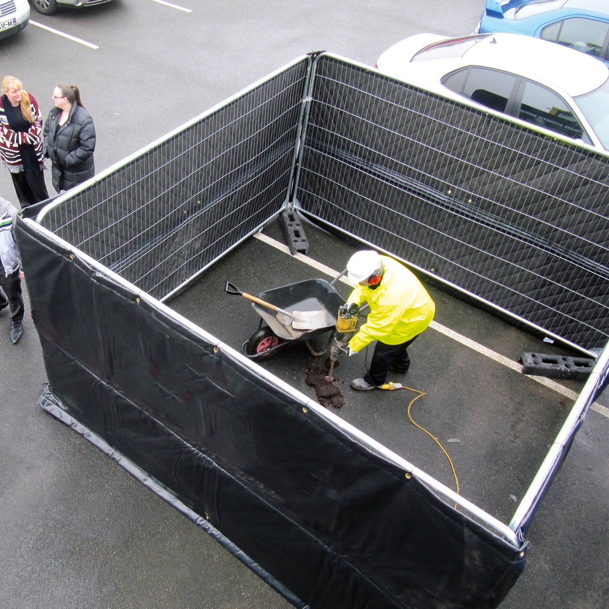 a person doing roadworks with the acoustic shields around him to block the noise